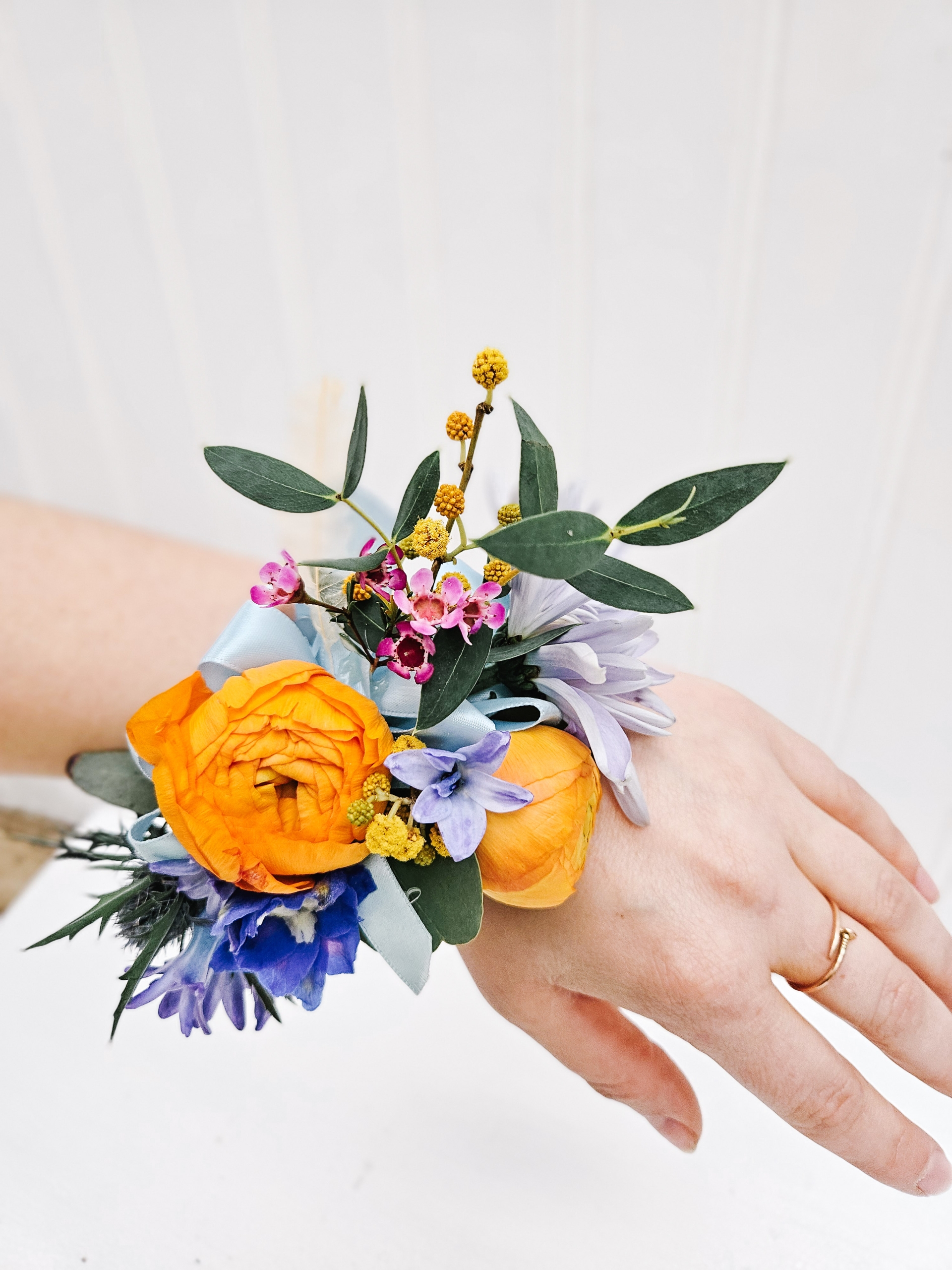 Orange and blue toned corsage for prom.