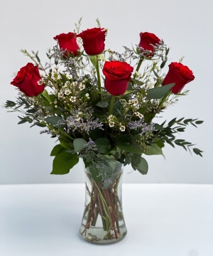 This is a classic simple vase of half dozen roses including greenery and filler florals.